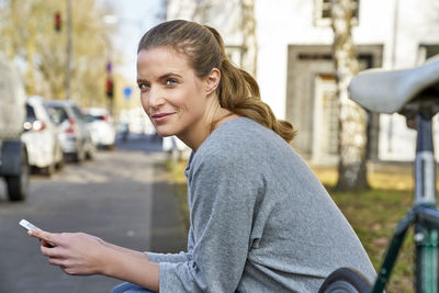 Portrait of smiling blond woman with cel phone