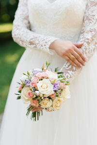 Beautiful wedding colorful bouquet in the hands of the bride. wedding ring on the finger