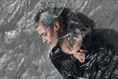 Woman seen through plastic against wall