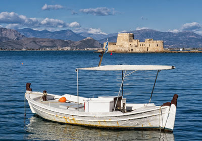 Sailboats moored on sea against sky