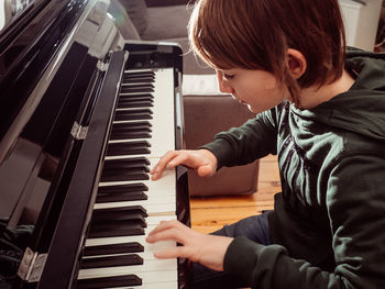 High angle view of boy playing piano at home