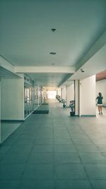 Woman walking on illuminated corridor