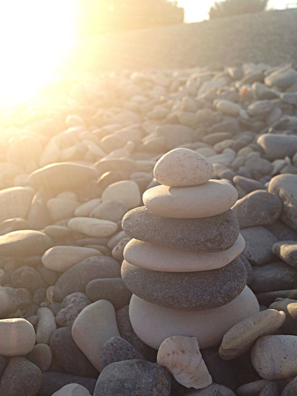 stone - object, stack, pebble, abundance, large group of objects, rock - object, sunlight, beach, stone, tranquility, balance, in a row, nature, textured, arrangement, day, pattern, outdoors, tranquil scene, heap