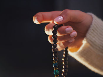 Cropped hand holding rosary beads