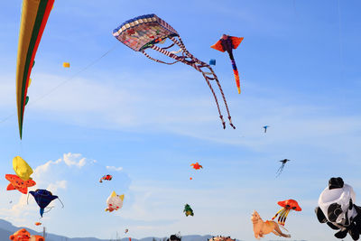 Low angle view of kites flying in sky