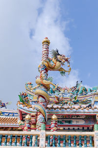 Low angle view of statue against temple against sky