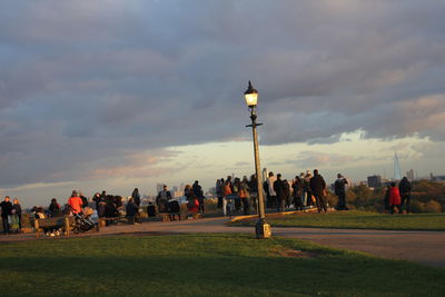 People in park against sky during sunset