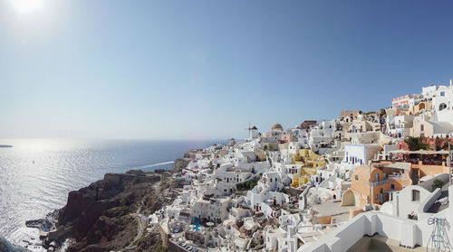 Panoramic view of townscape by sea against clear sky