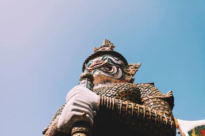 Low angle view of guardian statue against sky