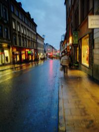 Wet illuminated city against sky