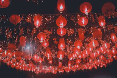 Low angle view of illuminated lanterns hanging at night