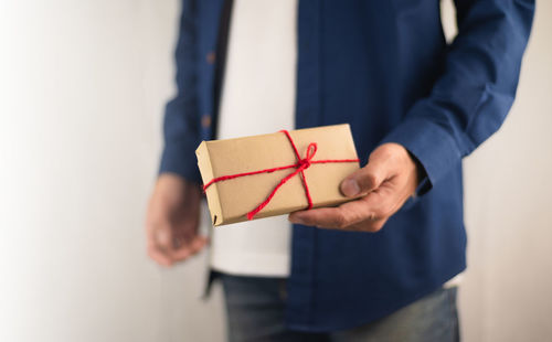 Midsection of man holding paper in box