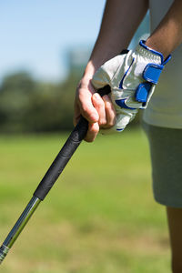Midsection of golfer gripping golf club