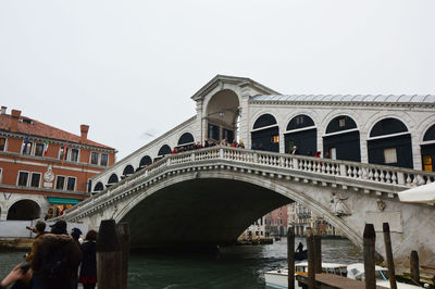 People at bridge against clear sky