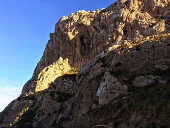 Low angle view of rocky mountains against sky