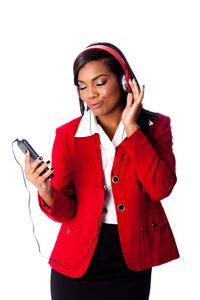 Young woman using phone while standing against white background