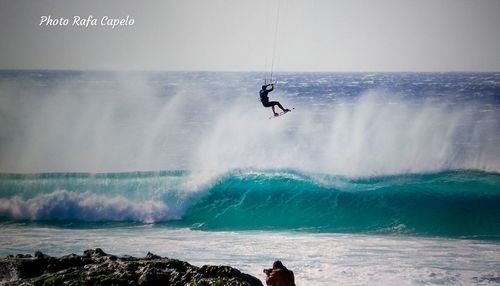 Man surfing in sea against sky