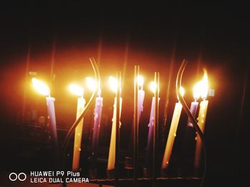 Close-up of lit candles in the dark