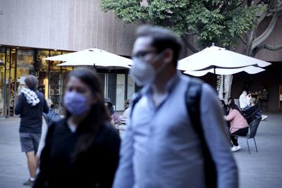 People walking on wet street in rainy season