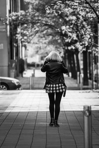 Rear view of woman walking on footpath