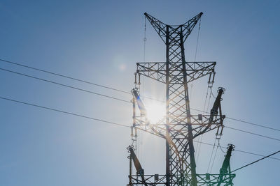 Low angle view of electricity pylon against clear sky