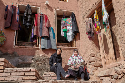 Panoramic view of people sitting outside house