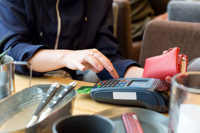 Woman pays with a bank credit card for lunch in restaurant via a wireless terminal, concept