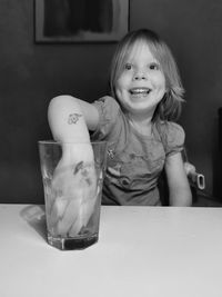 Portrait of a smiling girl sitting on table