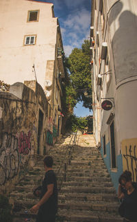Rear view of woman walking on road in city
