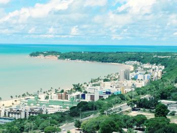 High angle view of cityscape by sea against sky