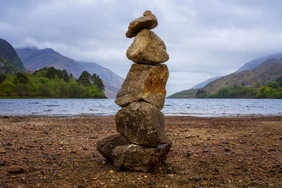 Stack of rocks on beach against sky