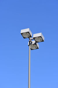 Low angle view of street light against blue sky