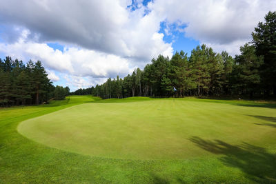 Scenic view of golf course against sky