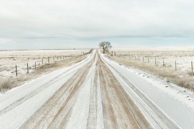 View of road passing through landscape against sky