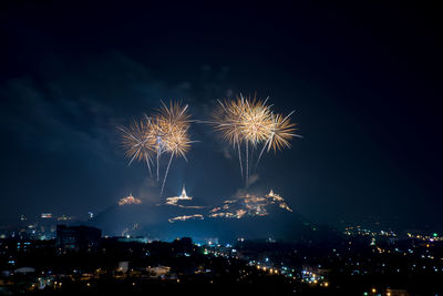 Firework display over cityscape at night