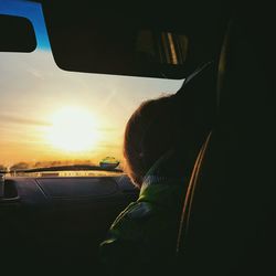 Rear view of man looking through car window