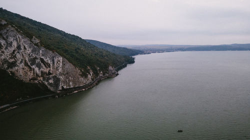 Scenic view of sea and mountains against sky