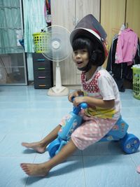 Cute girl sitting on tiled floor