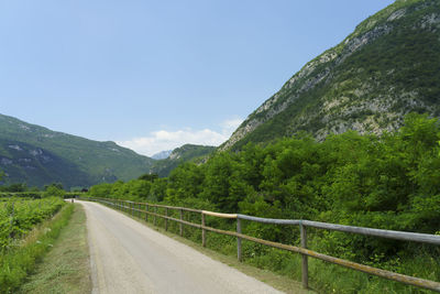 Road leading towards mountain against sky