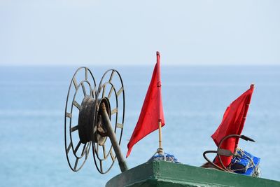 Orange flags on boat against sea