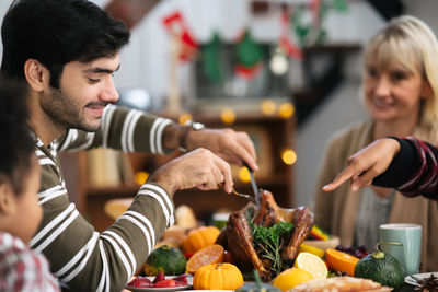 People sitting by food on table