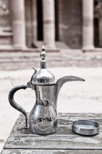 Close-up of old tea light on table against building