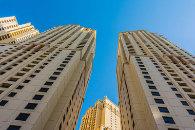 Low angle view of modern buildings against clear blue sky