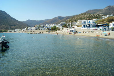 Scenic view of beach by buildings against sky