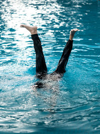 Rear view of woman swimming in sea