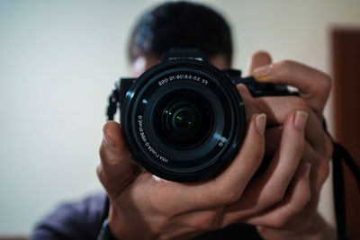 Close-up of man photographing with digital camera at home