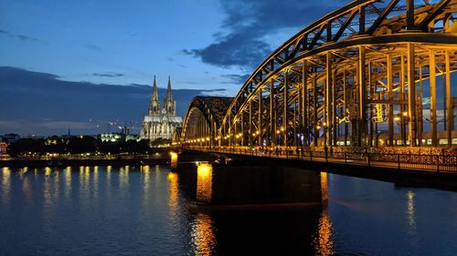 View of bridge over river at night in cologne