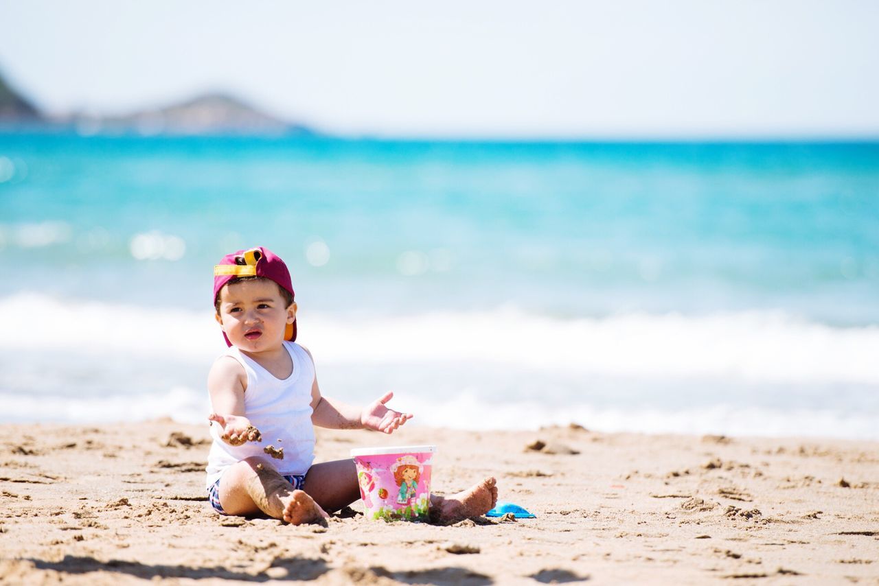 beach, sand, sea, shore, childhood, person, leisure activity, lifestyles, elementary age, boys, vacations, focus on foreground, water, smiling, innocence, cute, full length, happiness