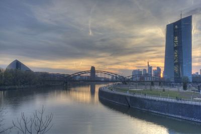 Bridge over river against cloudy sky