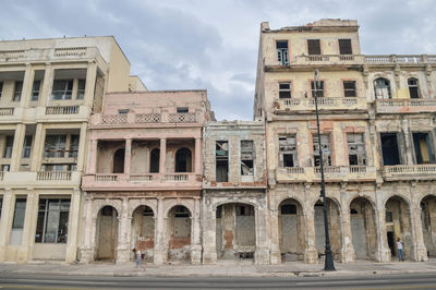 Facade of old building against cloudy sky